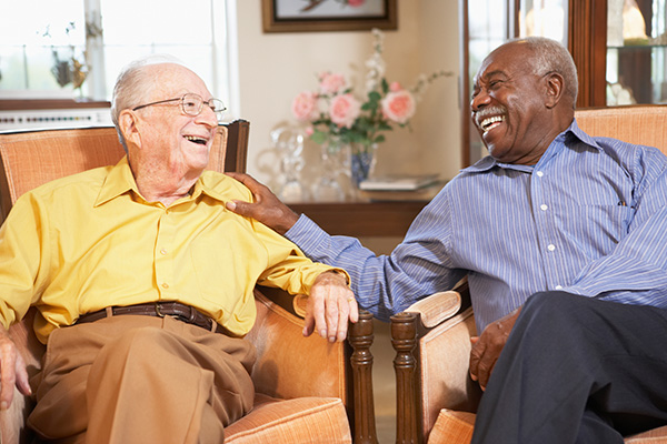 Senior men relaxing in armchairs and laughing together